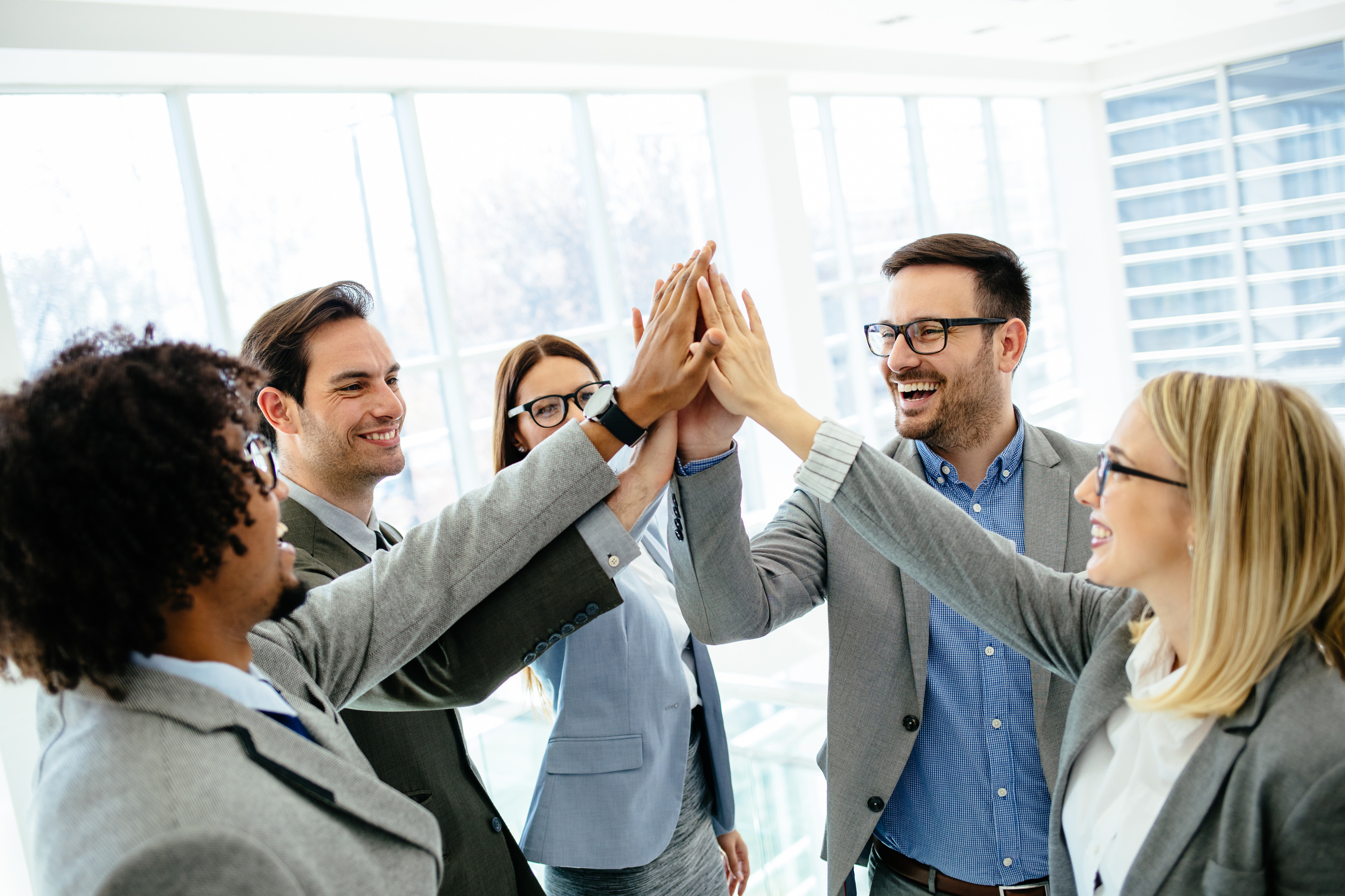 Excited business team give high five celebrating corporate success